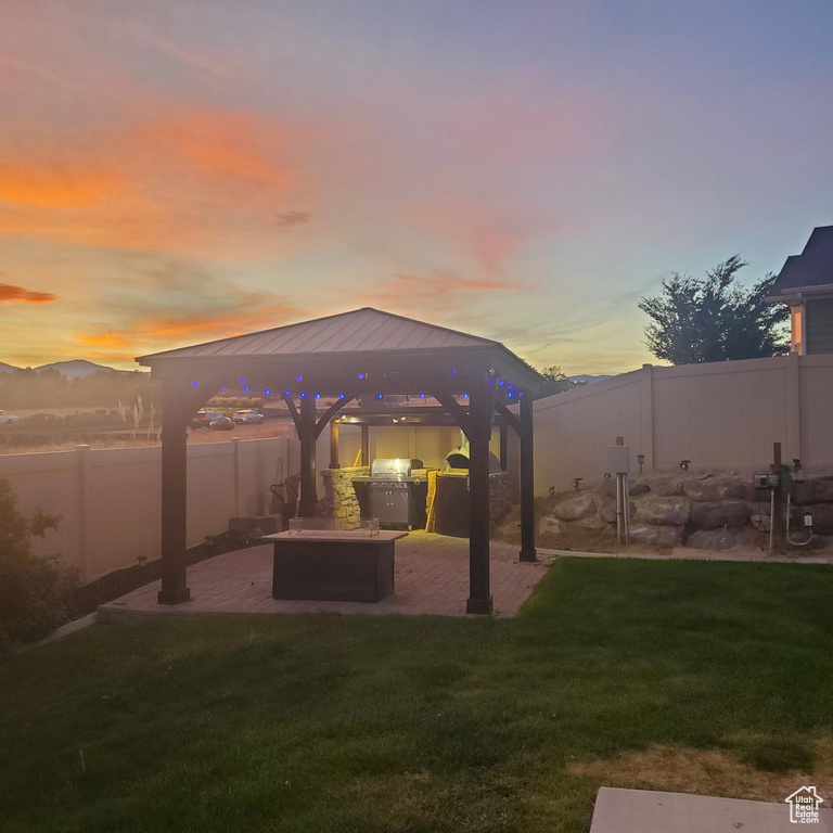 Yard at dusk featuring a patio and a gazebo