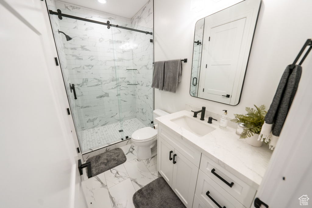 Bathroom featuring tile floors, an enclosed shower, toilet, and vanity