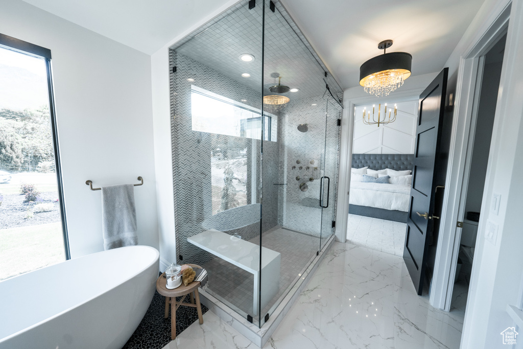 Bathroom with a shower with door, a chandelier, and tile flooring