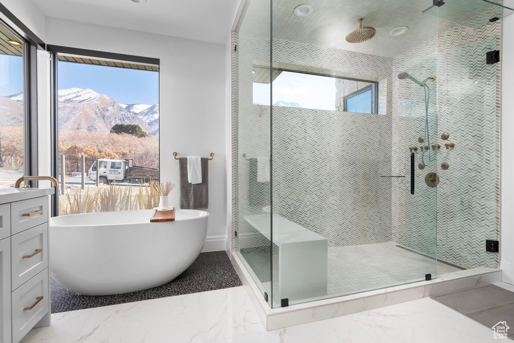 Bathroom featuring separate shower and tub, vanity, a mountain view, and tile floors