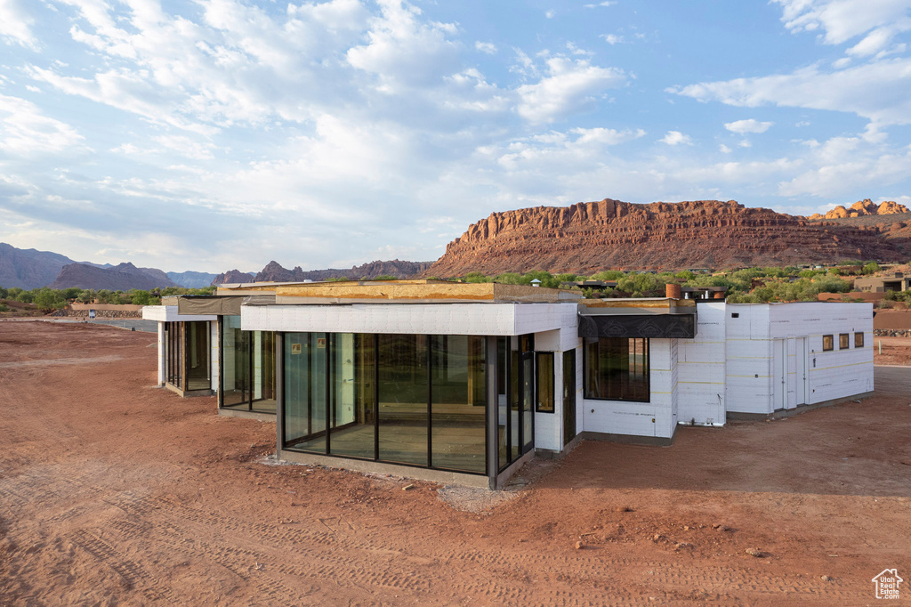 Rear view of property featuring a sunroom and a mountain view