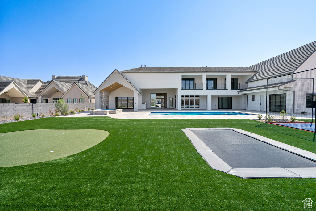 Back of house featuring a fenced in pool and a patio area