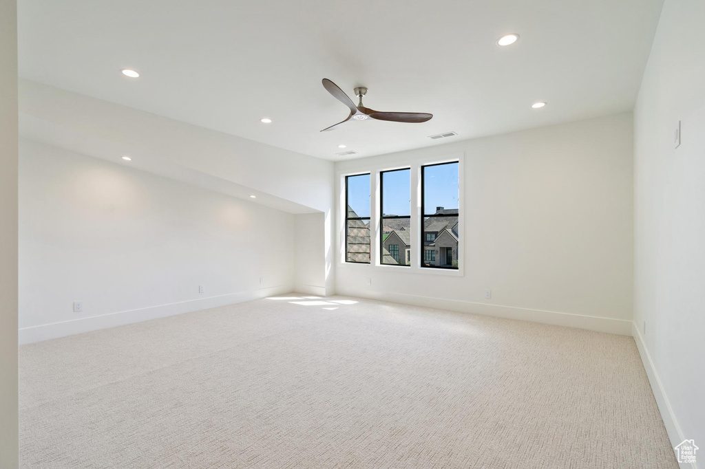 Unfurnished room featuring light colored carpet and ceiling fan