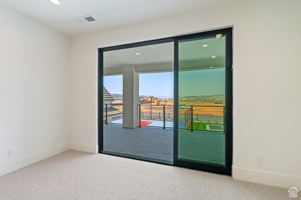 Doorway featuring light colored carpet