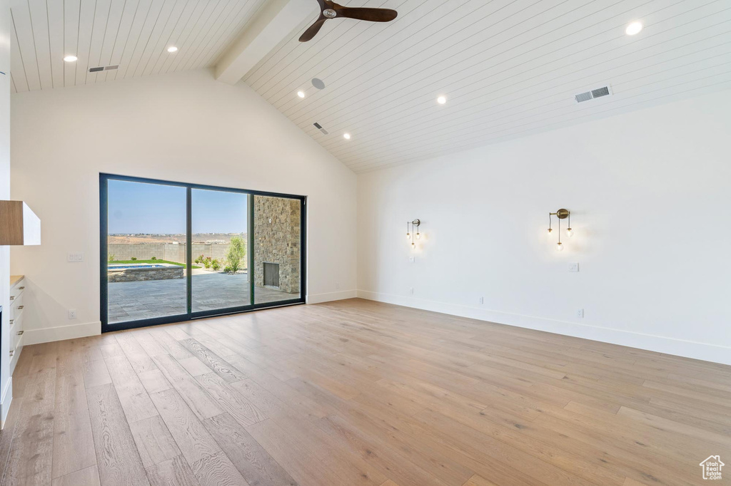 Spare room featuring light wood-type flooring, beamed ceiling, high vaulted ceiling, ceiling fan, and wooden ceiling