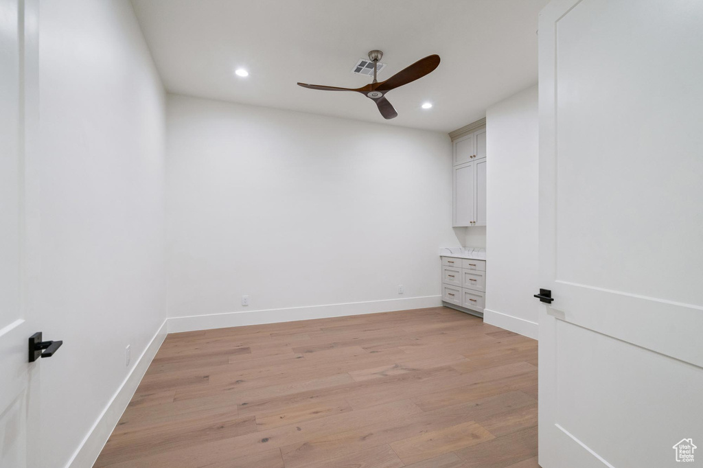 Spare room with light wood-type flooring and ceiling fan