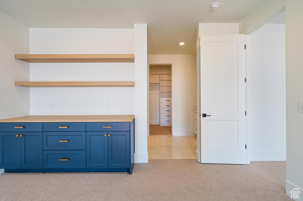 Interior space with light colored carpet and blue cabinets