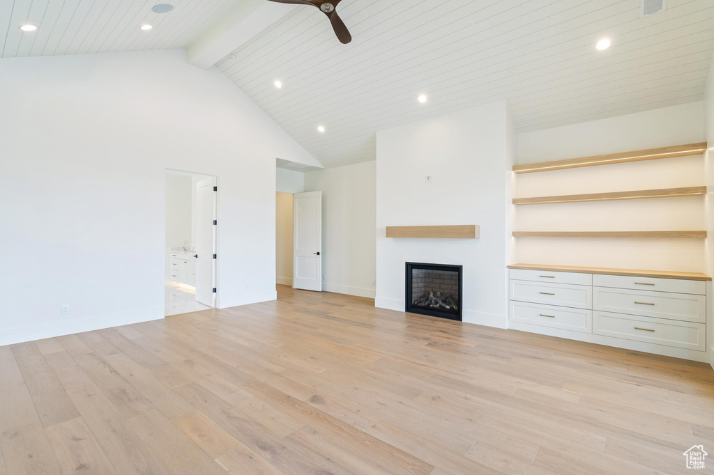 Unfurnished living room with beamed ceiling, wooden ceiling, high vaulted ceiling, ceiling fan, and light wood-type flooring