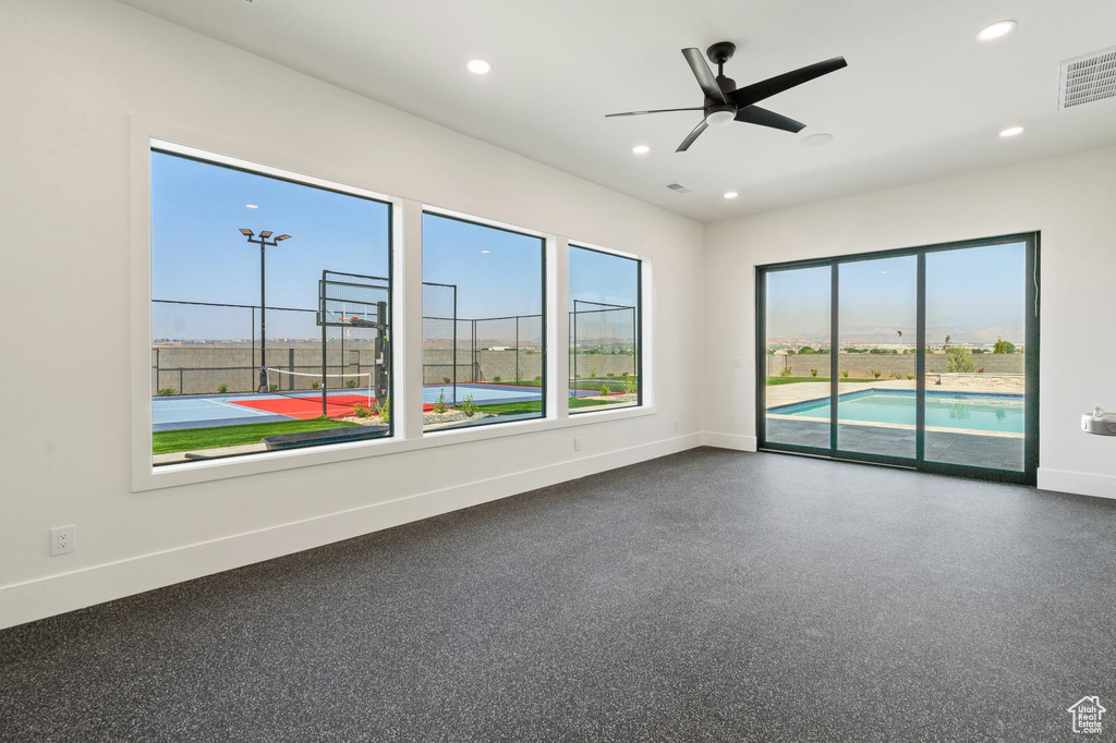 Unfurnished room with a wealth of natural light and ceiling fan