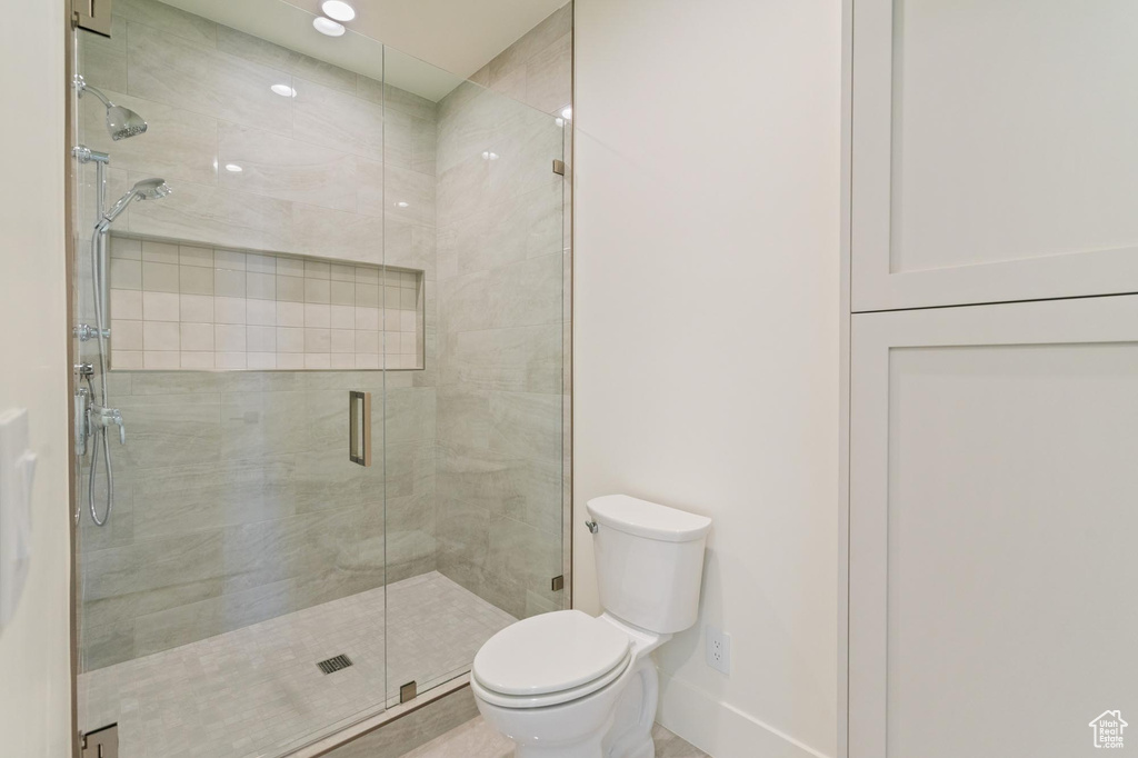 Bathroom featuring toilet and a shower with door