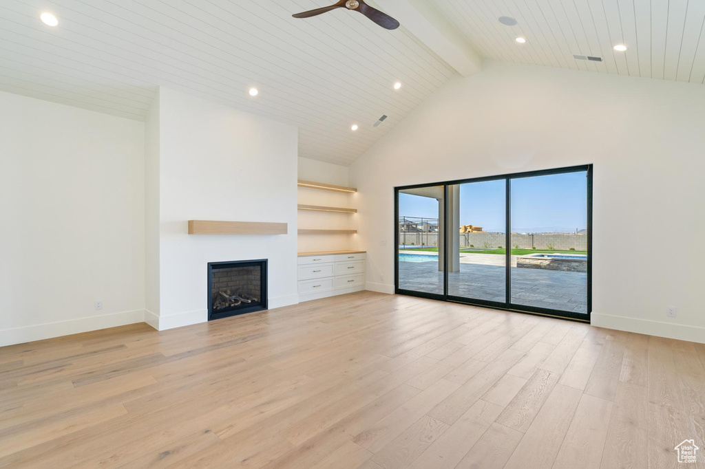 Unfurnished living room with light wood-type flooring, high vaulted ceiling, wood ceiling, ceiling fan, and beam ceiling