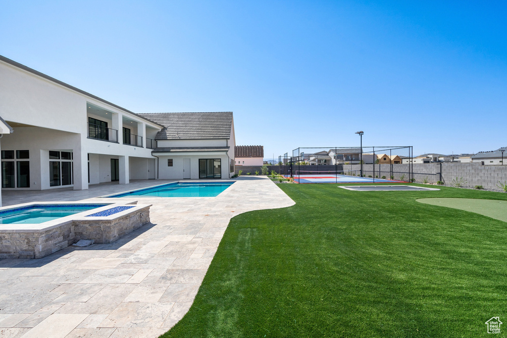 View of pool featuring an in ground hot tub, a lawn, and a patio area