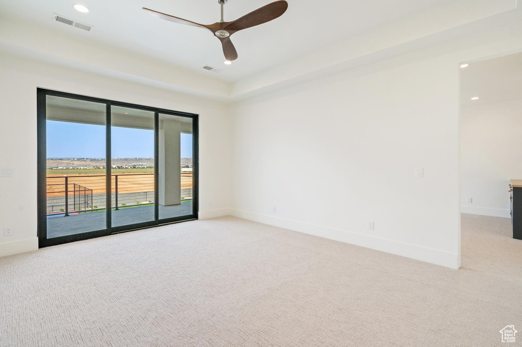 Carpeted empty room featuring ceiling fan