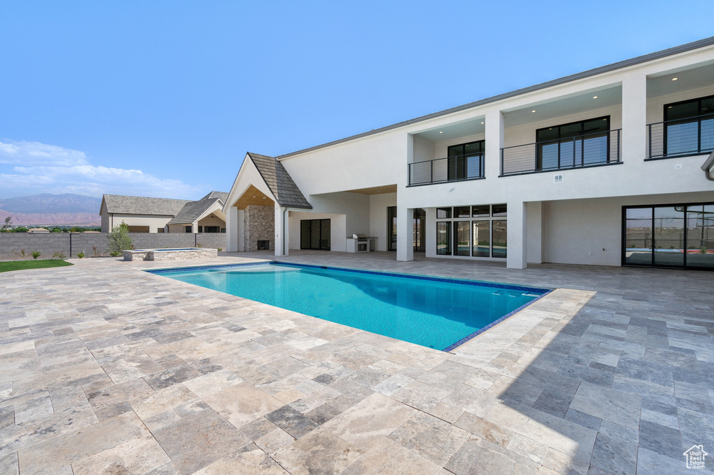 View of swimming pool with a mountain view and a patio