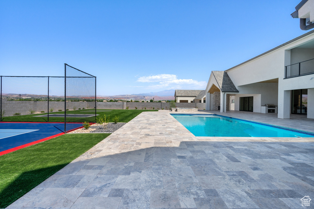 View of pool featuring area for grilling, a mountain view, a yard, and a patio