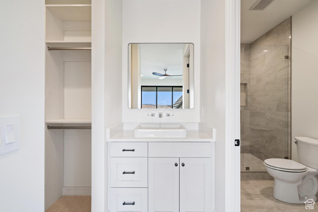 Bathroom featuring vanity, toilet, and an enclosed shower