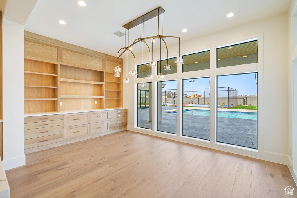 Unfurnished room featuring wood-type flooring and a chandelier