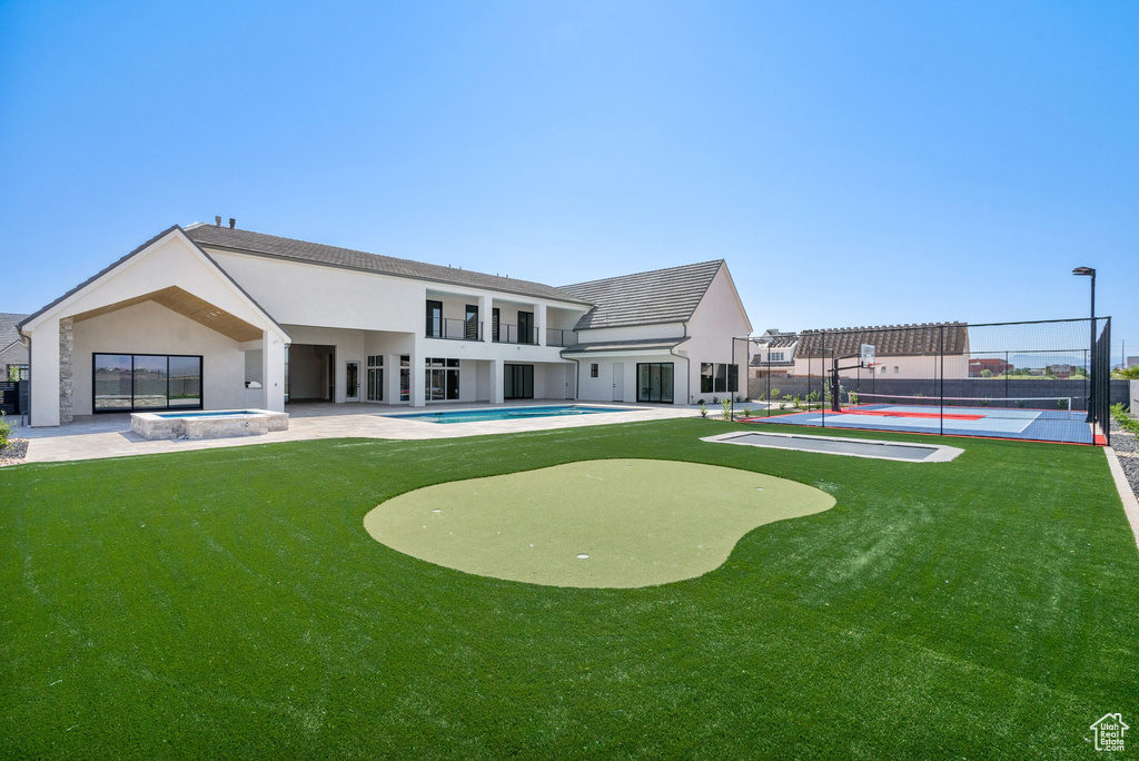 View of home\'s community with tennis court, a patio area, and a pool with hot tub