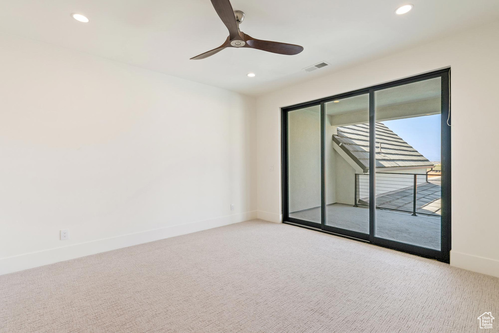 Carpeted empty room with ceiling fan