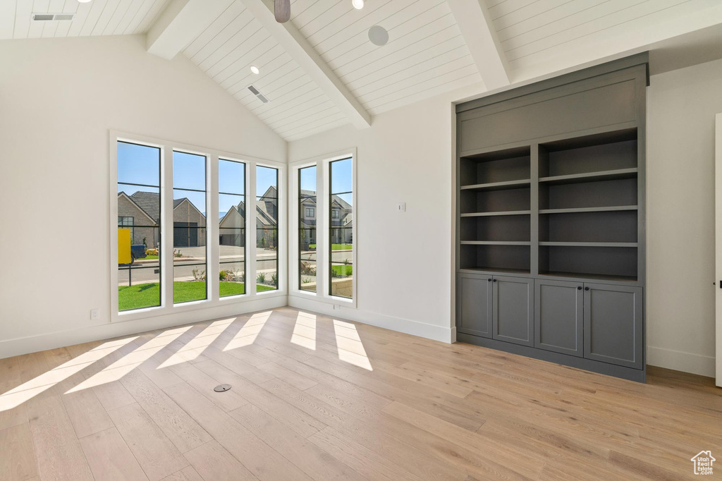 Unfurnished living room featuring wood ceiling, high vaulted ceiling, light wood-type flooring, and beam ceiling