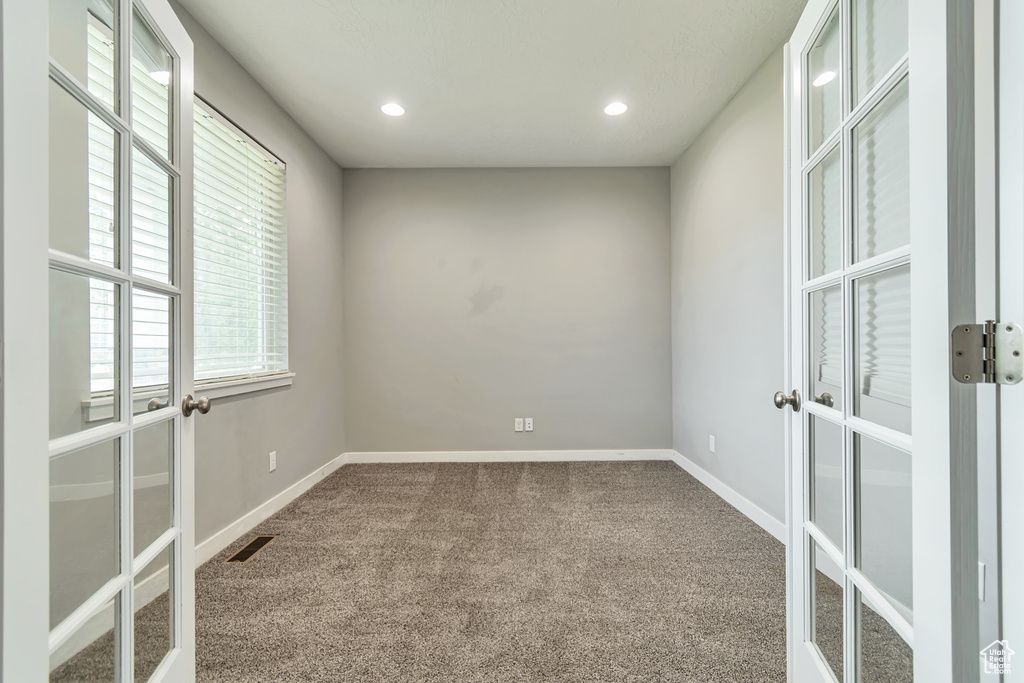 Empty room featuring carpet floors and french doors