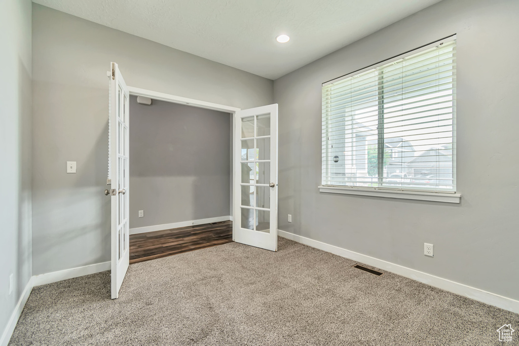Unfurnished bedroom with french doors and carpet flooring