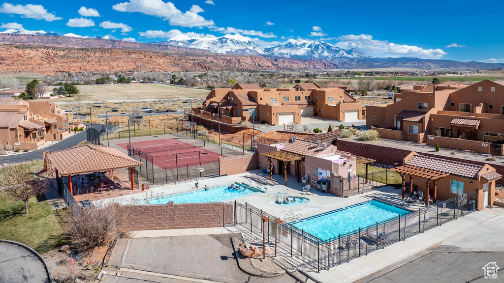 View of swimming pool with a patio area, a mountain view, and a community hot tub