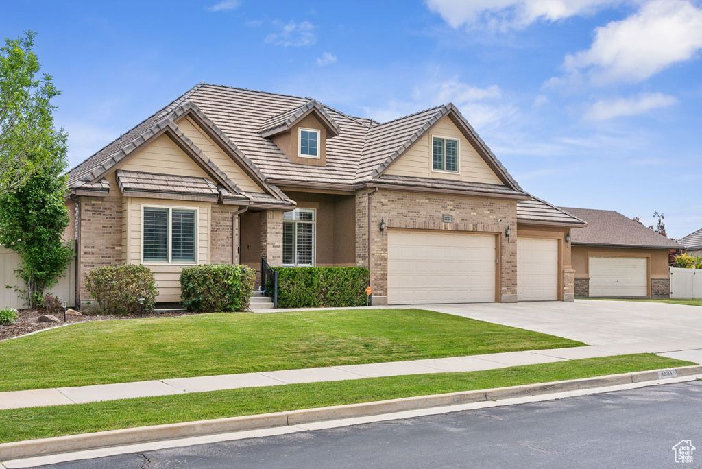 View of front of property with a garage and a front yard