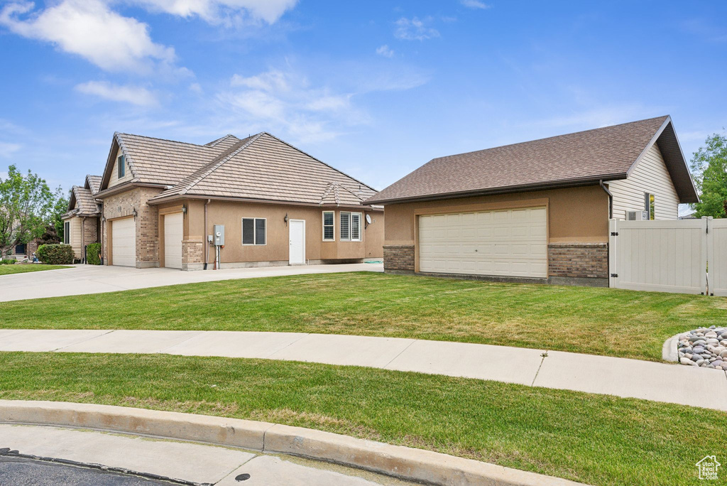 View of front of home with a garage and a front lawn