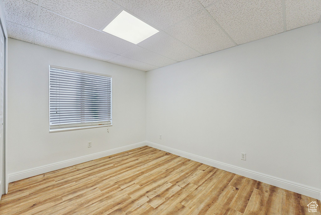 Empty room featuring light hardwood / wood-style floors and a drop ceiling