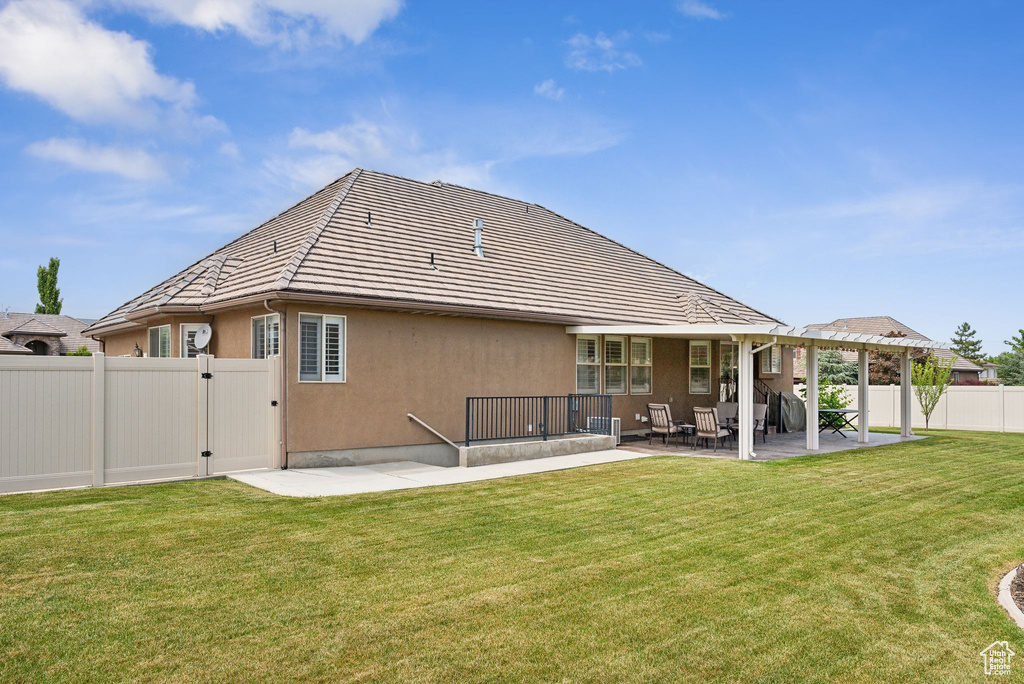 Back of house with a patio area and a yard