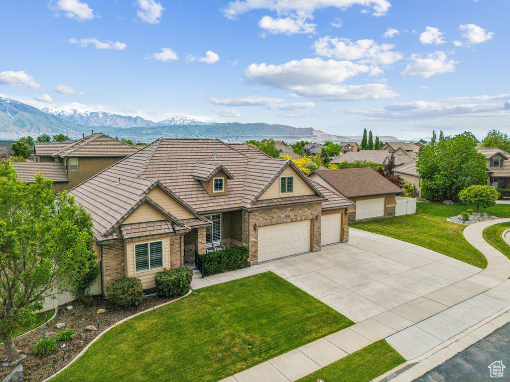 View of front of home featuring a front yard, a garage, and a mountain view