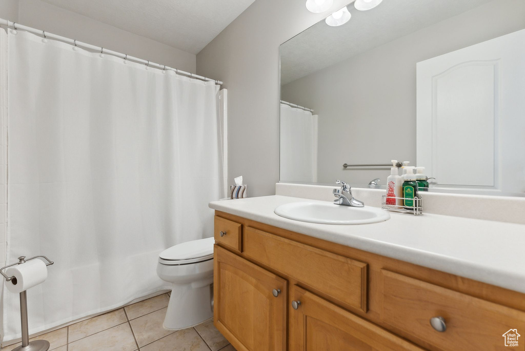 Bathroom with tile flooring, vanity, and toilet