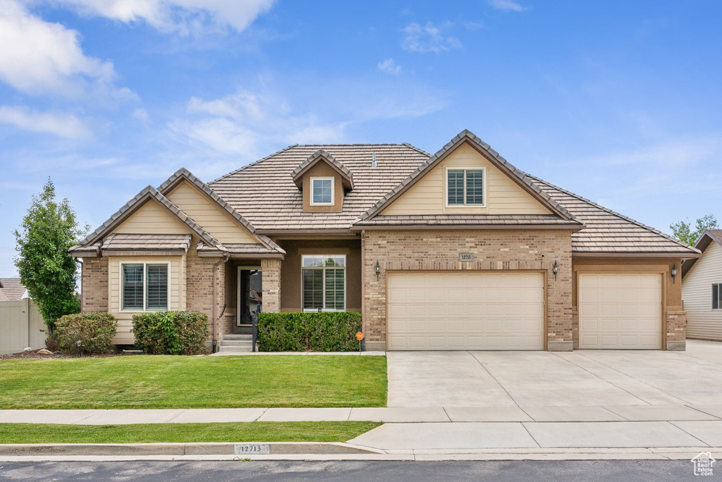 View of front of house featuring a garage and a front yard