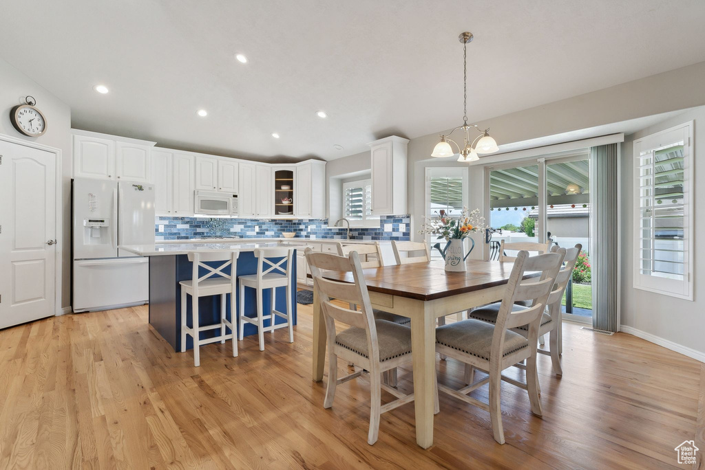 Dining room featuring light hardwood / wood-style floors, sink, and a notable chandelier