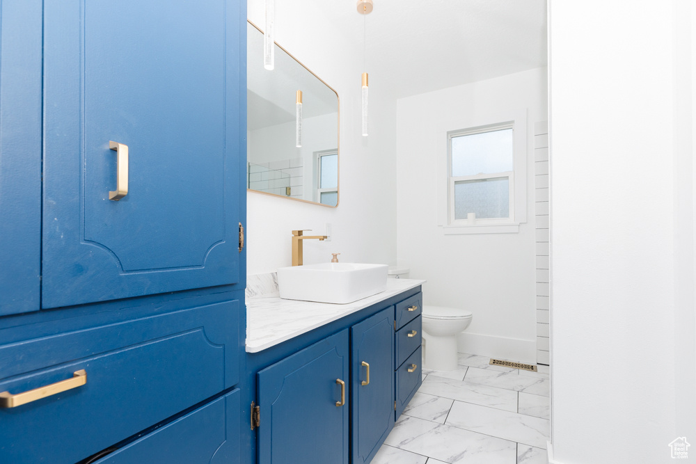 Bathroom featuring tile floors, vanity, and toilet