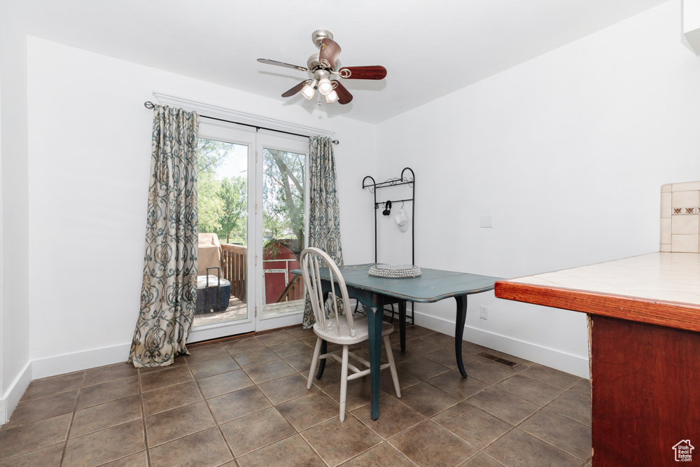 Tiled dining area featuring ceiling fan