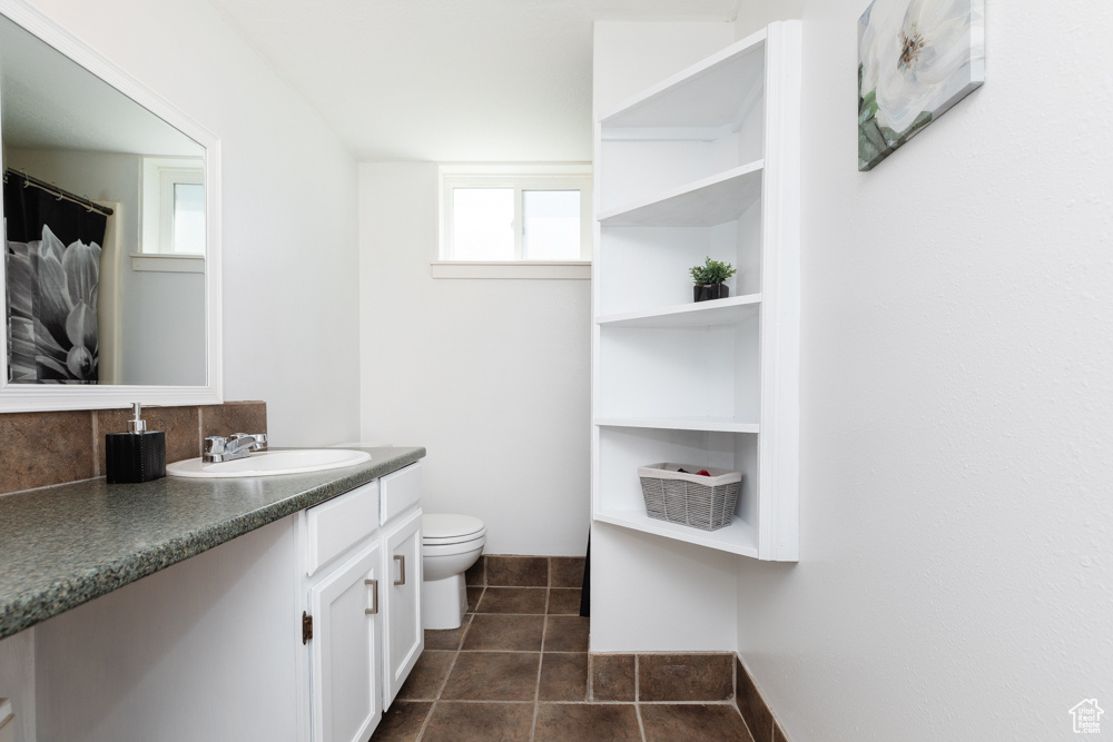 Bathroom featuring tile floors, tasteful backsplash, toilet, and vanity