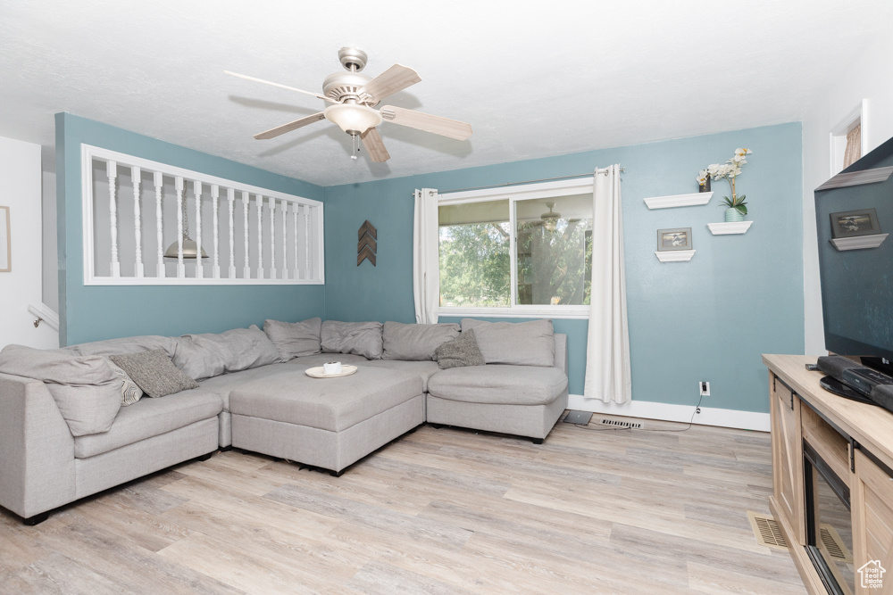 Living room featuring light wood-type flooring and ceiling fan