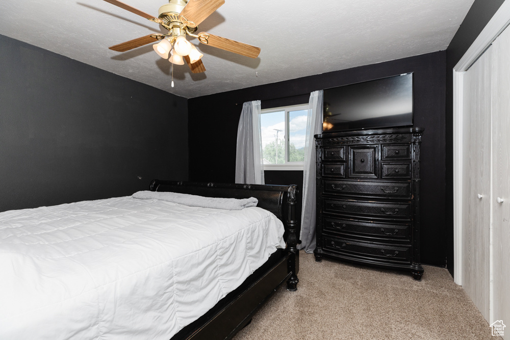 Bedroom featuring ceiling fan and light carpet