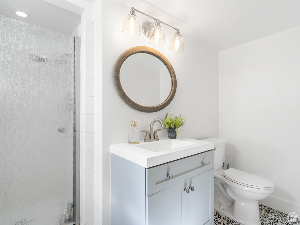 Bathroom with walk in shower, vanity, toilet, and tile floors