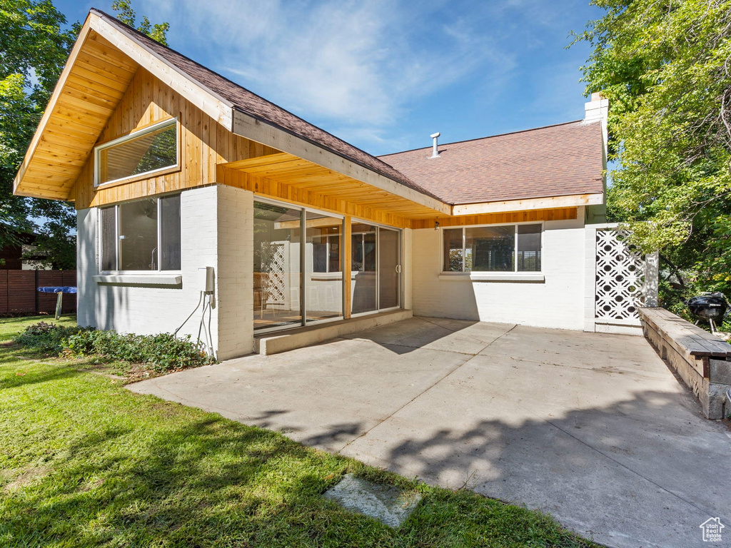 Back of property with a patio and a lawn