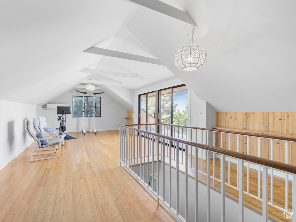 Hallway with vaulted ceiling and light wood-type flooring