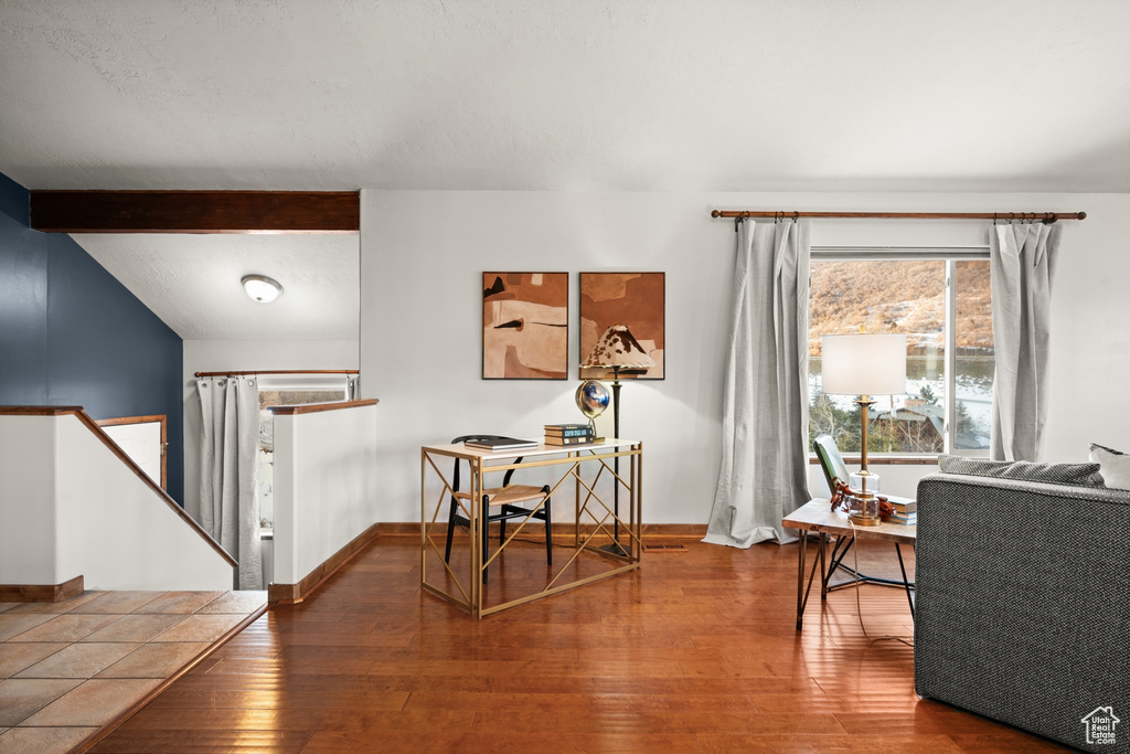 Interior space with beamed ceiling and hardwood / wood-style floors