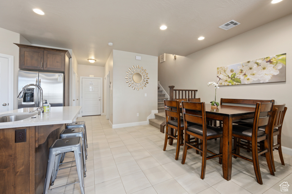 Dining area with sink and light tile floors