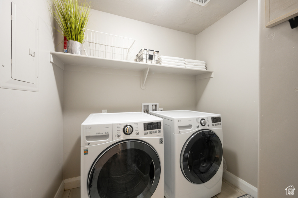 Laundry room with tile floors, hookup for a washing machine, and washing machine and clothes dryer