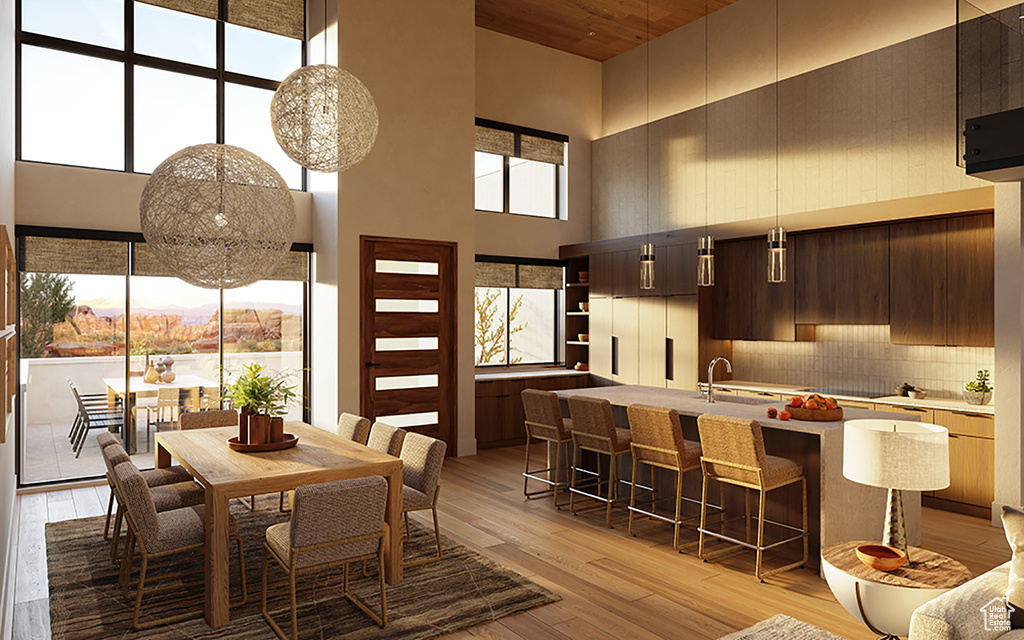 Dining space featuring a high ceiling, sink, and light wood-type flooring