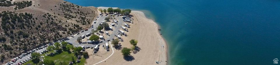 Birds eye view of property with a beach view and a water view