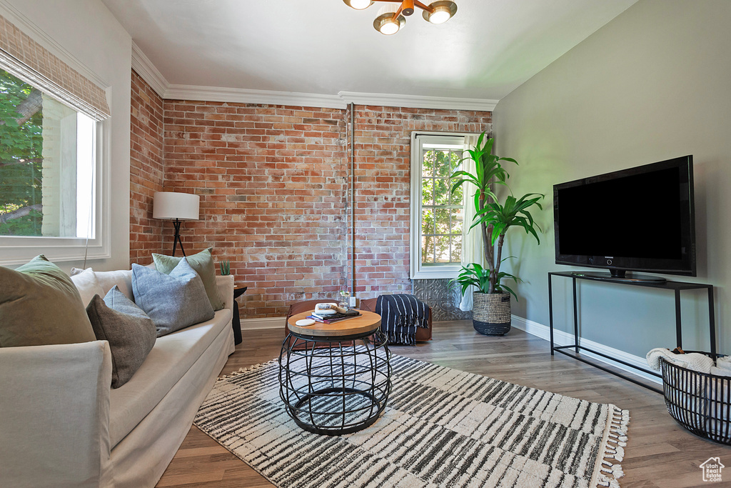 Living room with brick wall and wood-type flooring