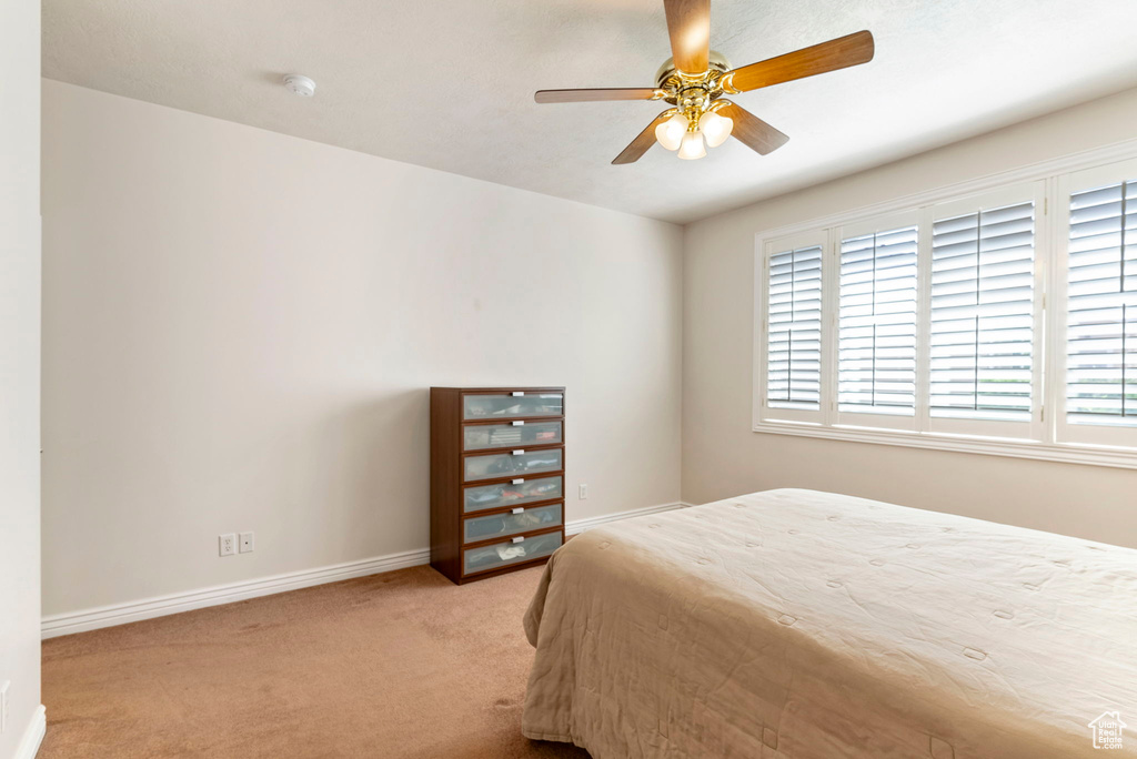 Carpeted bedroom featuring ceiling fan